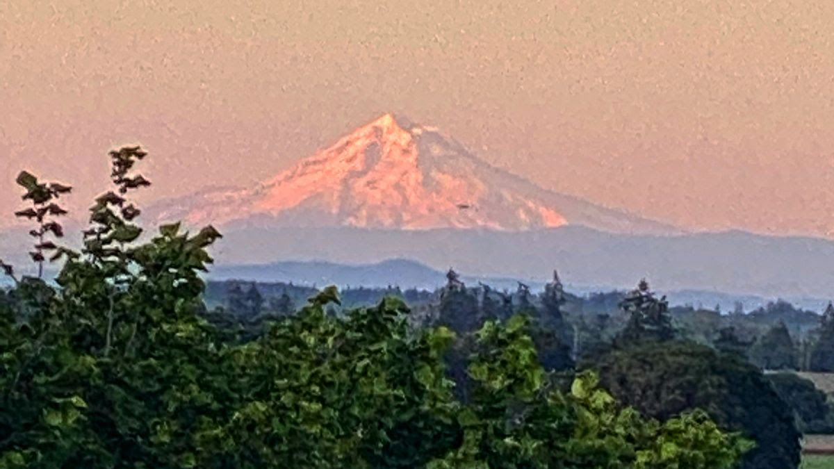 A beautiful shot of Mount Hood prominently displayed along the Cascade Range overlooking Willamette Valley's abundant and fertile floor below.