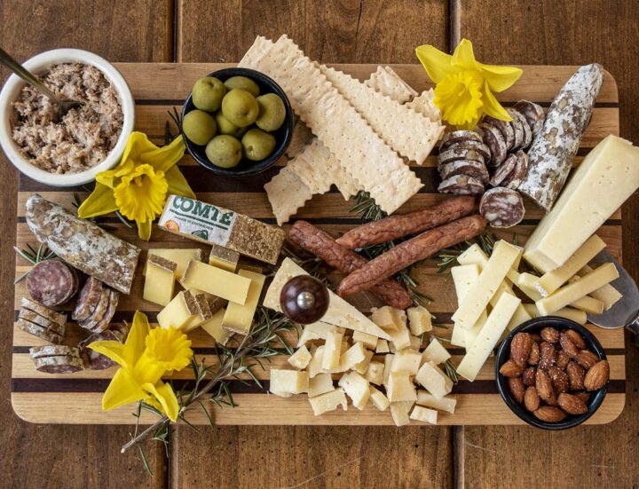 Platter of cheese and meat dishes plus olives, nuts, and bread