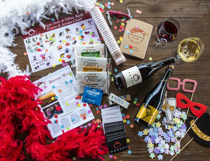 Two bottles of Brooks Wine plus confetti, chocolate, feather boas, tasting guides, and assorted party items