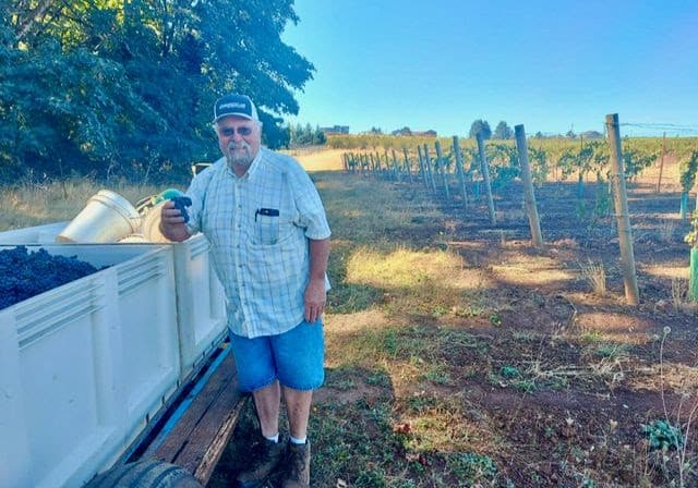 Mr Crannell with a picking bin full of his fruit