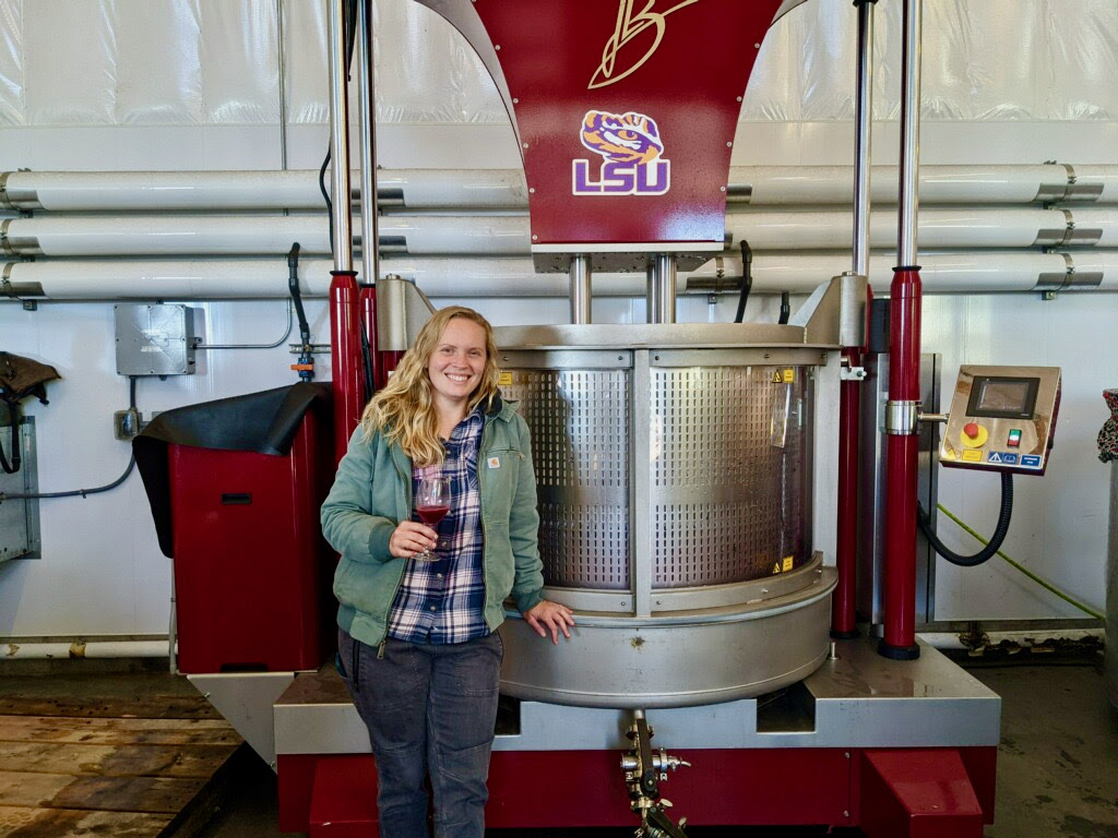 Associate Winemaker, Claire, stands in front of our red wine press