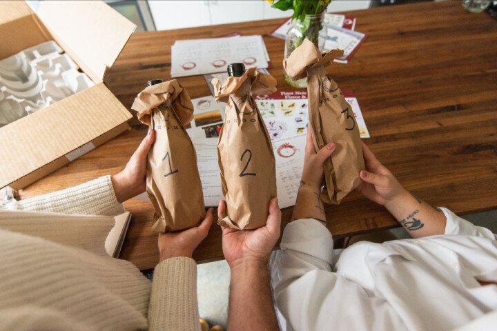 Three bottles of Brooks Wine wrapped in brown paper bags.