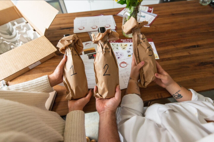 Three bottles of Brooks Wine wrapped in brown paper bags. 