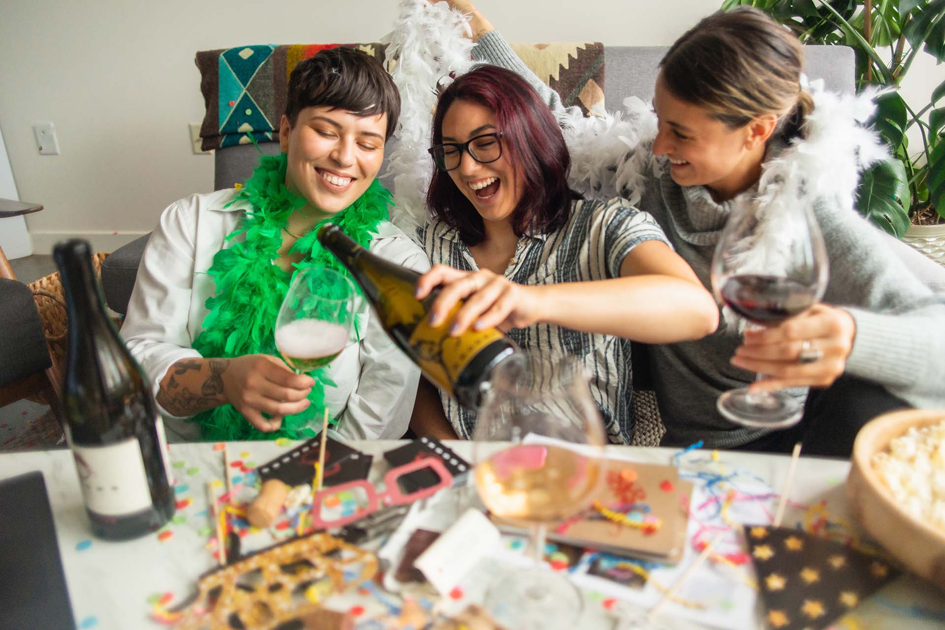 Three friends drinking Brooks Sparkling wine while celebrating with party embellishments
