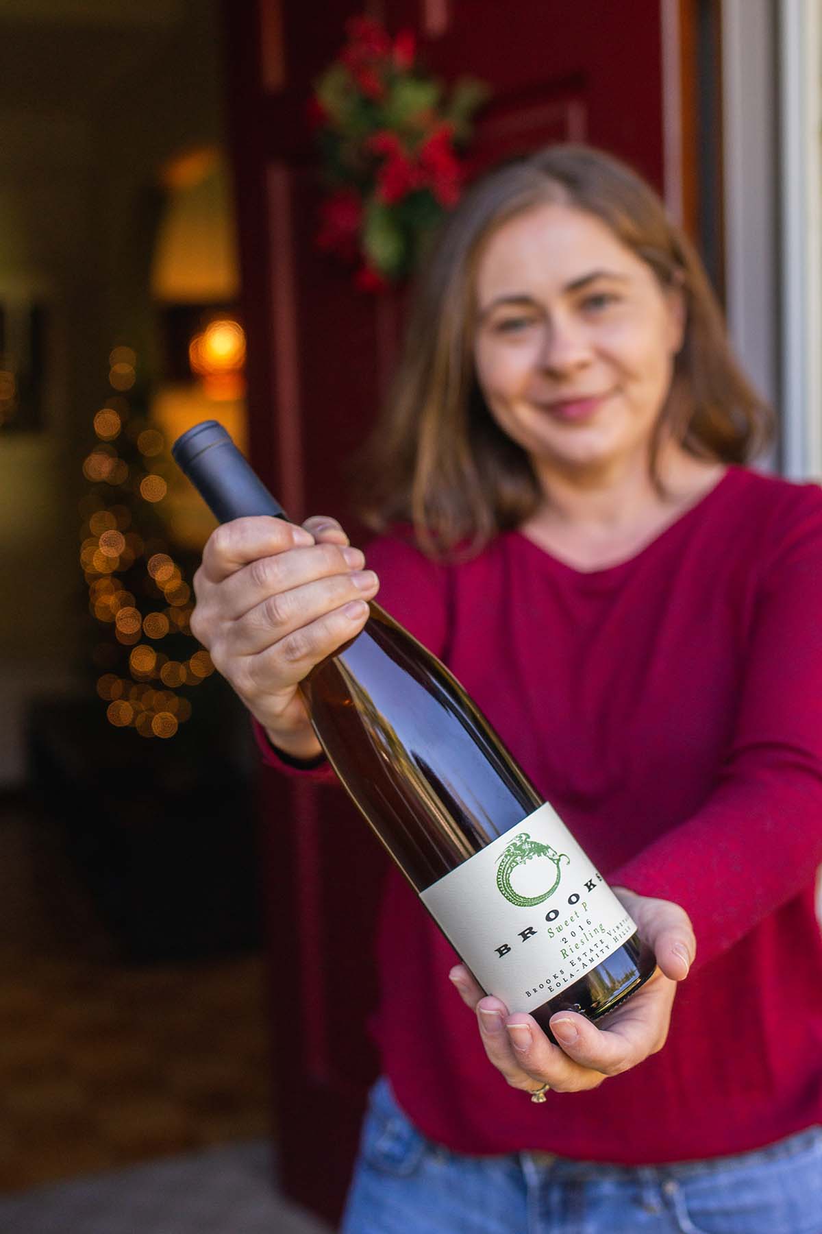Woman holding bottle of Brooks Riesling at her front door