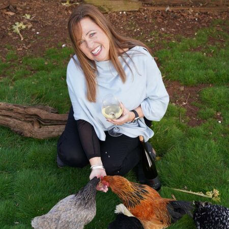 Heather drinking white wine while feeding the Brooks chickens