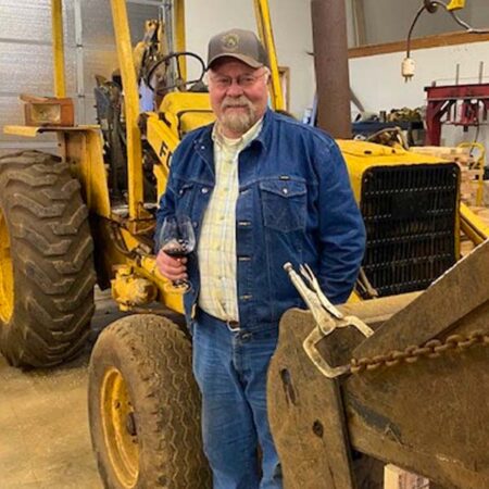 Dick Crannell in front of winery tractor