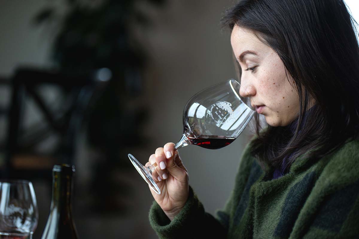 Young woman with nose in wine glass during wine tasting experience