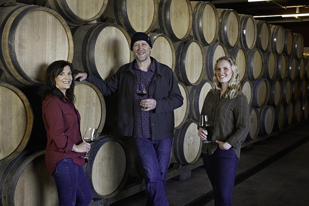 Claire Jarreau, newly appointed Head Winemaker at Brooks Winery, stands in the Barrel Room alongside esteemed Winemaker and mentor, Chris Williams, and Managing Director, Janie Heuck.
