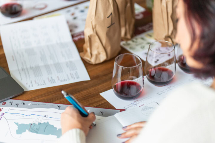 A wine novice tasting two glasses of red wine side by side to learn how to describe wine more accurately.